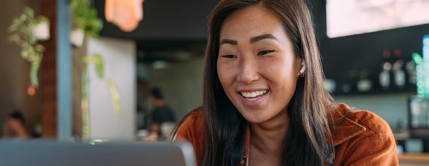 a woman smiling while working on laptop