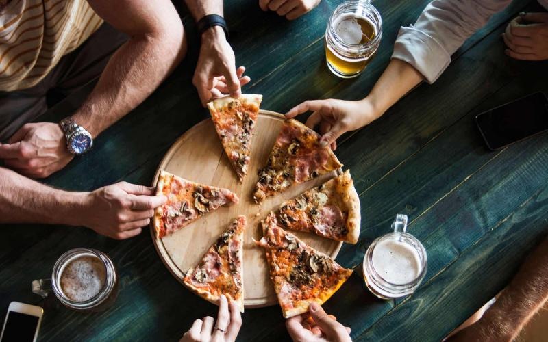 a group of people eating pizza